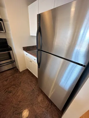 a kitchen with stainless steel appliances granite countertop a refrigerator a stove and a sink