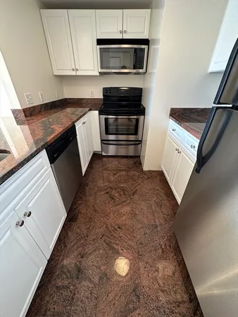 a kitchen with granite countertop a sink and a stove top oven