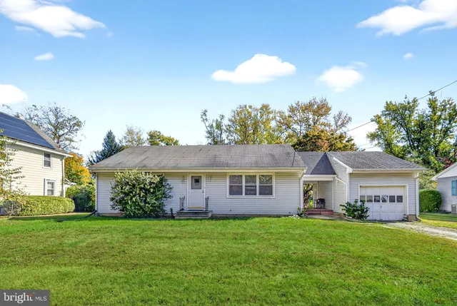 a view of a house with a big yard and a large tree