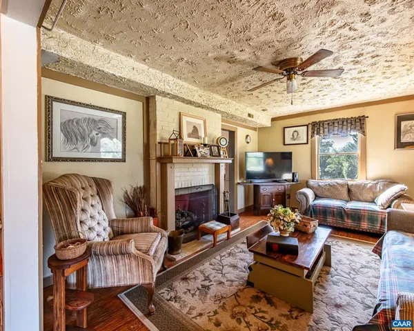 a living room with furniture a flat screen tv and a fireplace
