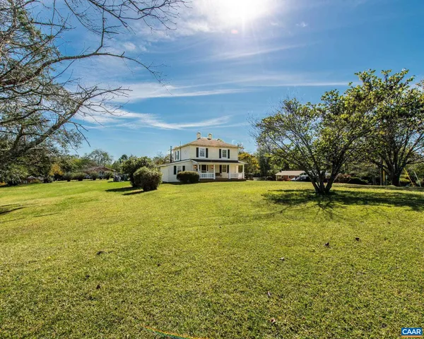a view of a big yard with potted plants and large trees