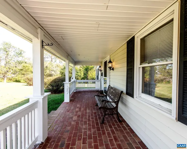 a balcony with wooden floor and outdoor seating