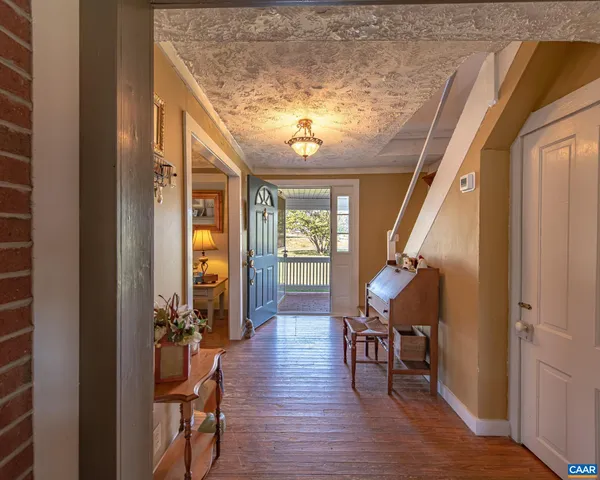 a view of a hallway with furniture and wooden floor