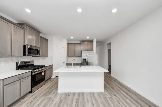 a large white kitchen with stainless steel appliances