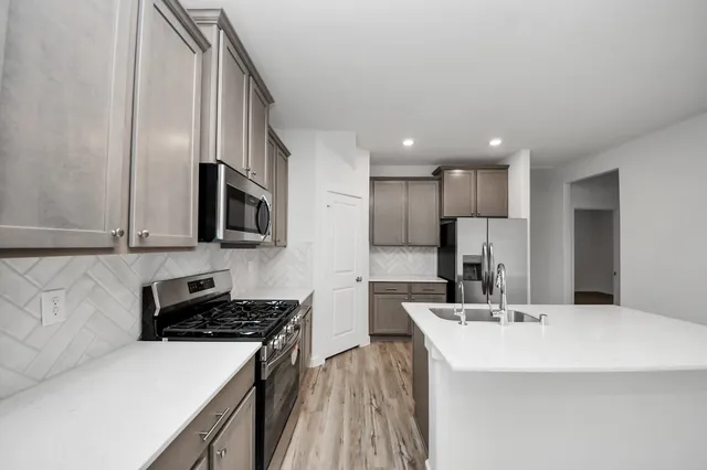 a kitchen with stainless steel appliances a sink stove and refrigerator