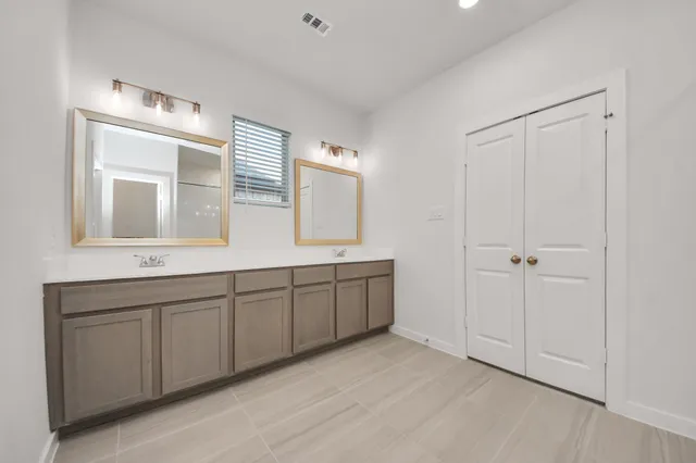 a spacious bathroom with a double vanity sink a mirror and a bathtub