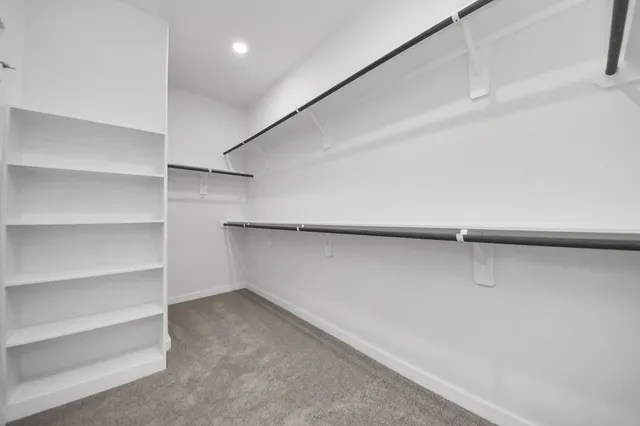 a view of walk in closet with empty racks