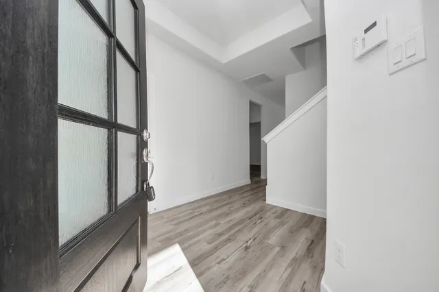 a view of hallway with stairs and wooden floor