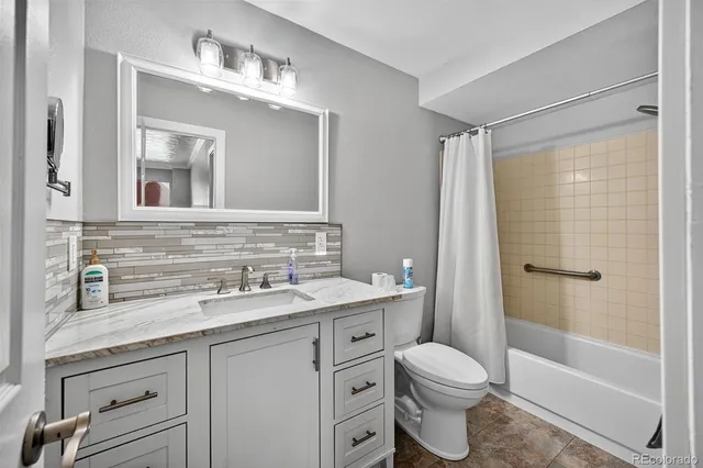 a bathroom with a granite countertop toilet sink and a mirror