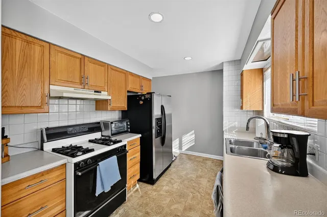 a kitchen with a stove a refrigerator and a sink
