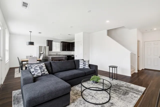 a living room with furniture and wooden floor