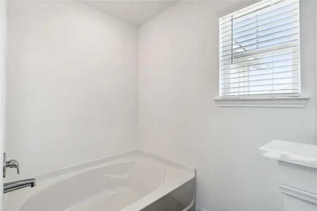 a white bath tub sitting next to a white toilet