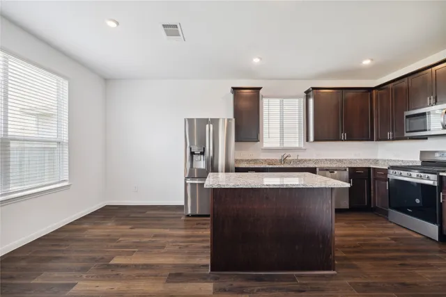 a kitchen with stainless steel appliances granite countertop a stove and a refrigerator