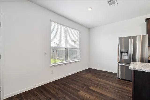 an empty room with wooden floor and a window