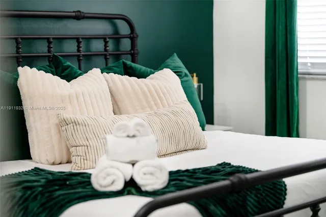 a bed sitting in a bedroom next to a window with wooden floor