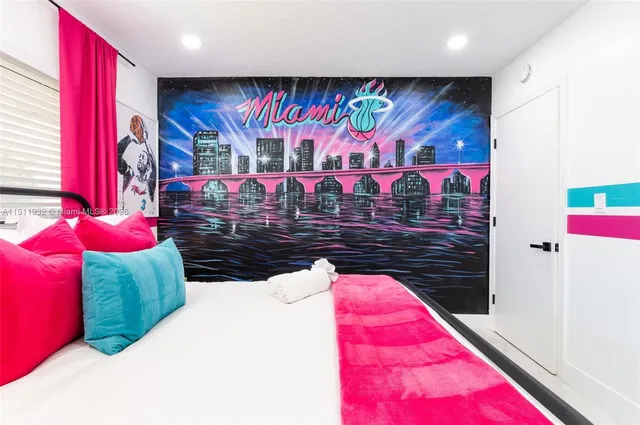 a living room with a bed furniture flat screen tv and painting on the wall