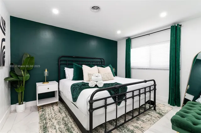 a bedroom with a bed and large windows