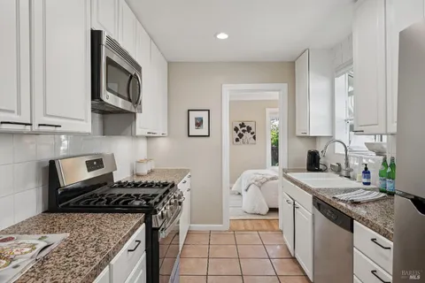 a kitchen with granite countertop a sink and a stove top oven
