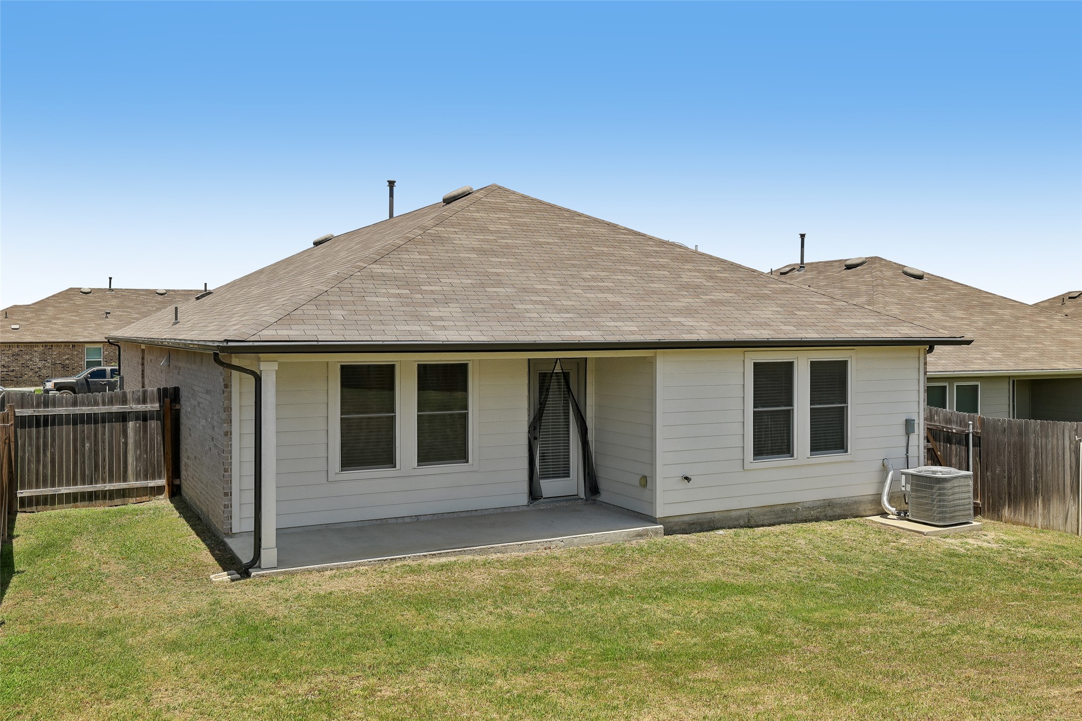19805 Abigail Fillmore Road Manor, TX 78653 - Photo 28 of 40 A well-maintained backyard with a modest patio extends from this comfortable residence.