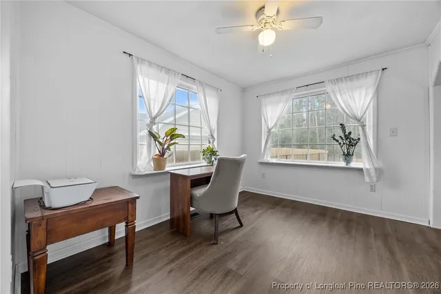 a view of a workspace with furniture and a window