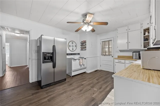 a kitchen with stainless steel appliances granite countertop a refrigerator a stove a microwave oven a sink with island and chairs