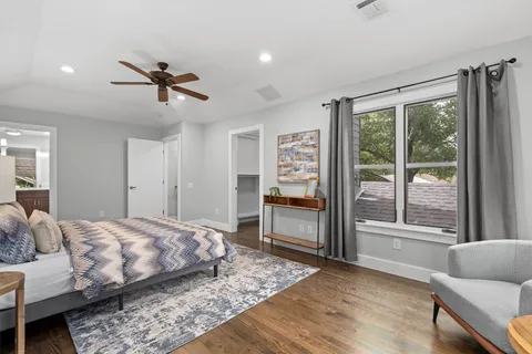 a spacious bathroom with a granite countertop double vanity sink a mirror and a shower