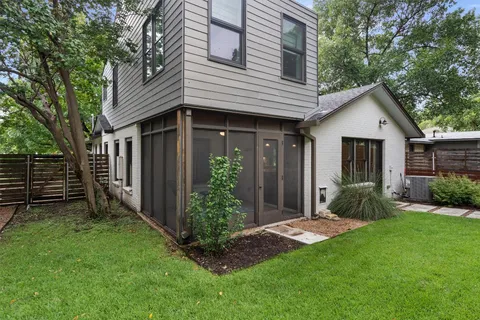 a view of a backyard with plants and large trees