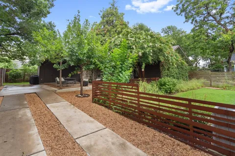 a view of a chair and table in backyard of the house
