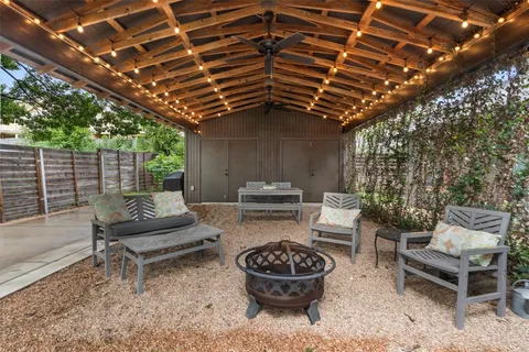 a view of a chair and table in backyard of the house