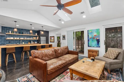 a living room with furniture a flat screen tv and kitchen view