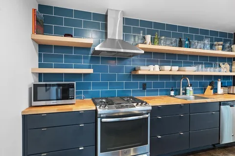 a room with kitchen island a sink and wooden floor
