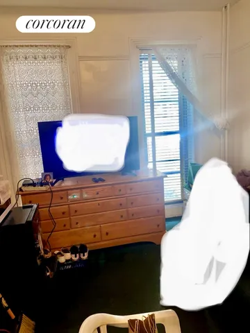 a view of a refrigerator in kitchen and an empty room