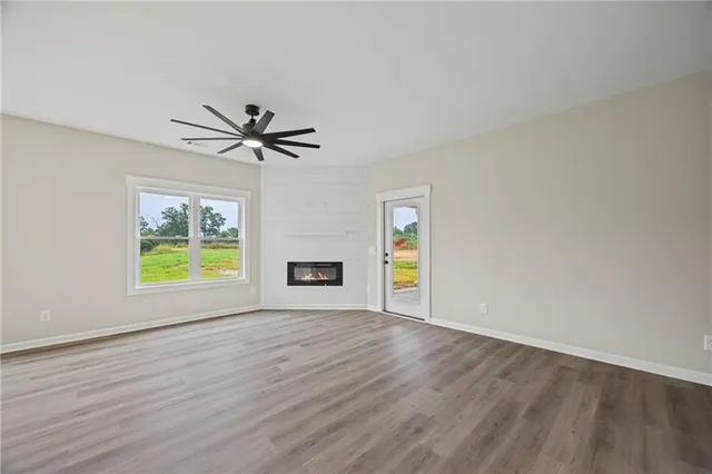 a view of an empty room with a window and wooden floor