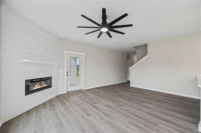 a view of empty room with wooden floor and ceiling fan