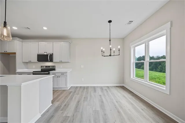 a kitchen with granite countertop stainless steel appliances a stove a sink a center island and a window