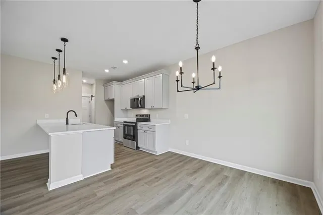 a view of kitchen with sink microwave and wooden floor