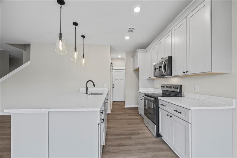 613 Racetrack Road Toccoa, GA 30577 - Photo 18 of 47 a kitchen with white cabinets sink and stainless steel appliances