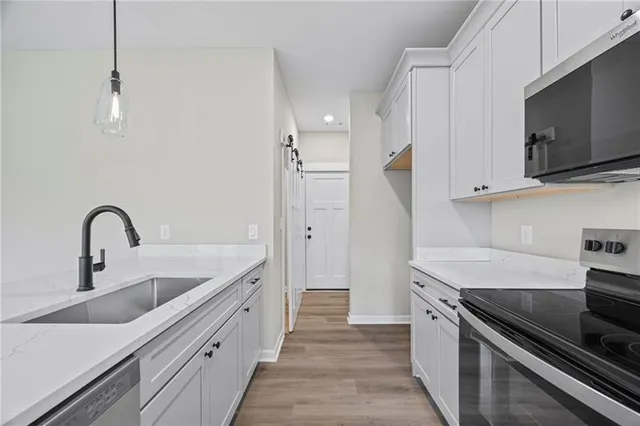 a kitchen with stainless steel appliances granite countertop a sink and a stove