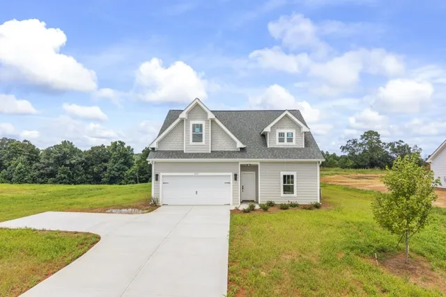 a view of a house with a yard and fence