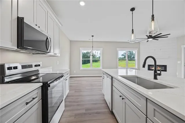 a kitchen with stainless steel appliances a sink a stove and microwave