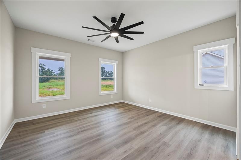 613 Racetrack Road Toccoa, GA 30577 - Photo 24 of 47 a view of a big room with wooden floor a ceiling fan and windows