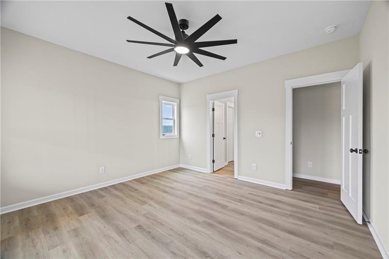 613 Racetrack Road Toccoa, GA 30577 - Photo 25 of 47 an empty room to hallway with wooden floor a ceiling fan and windows