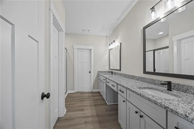 a spacious bathroom with a granite countertop sink and a mirror