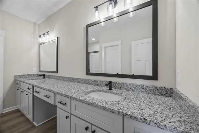 a bathroom with a granite countertop sink and a mirror