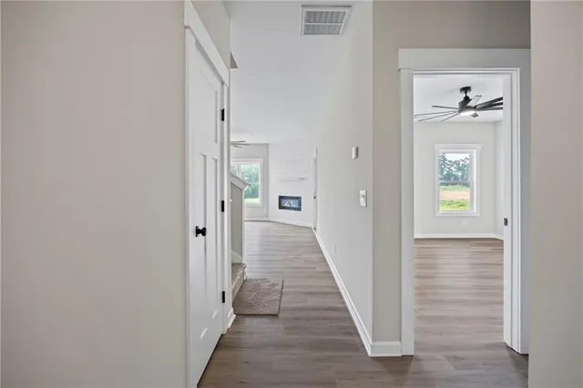 a view of a hallway with wooden floor and closet
