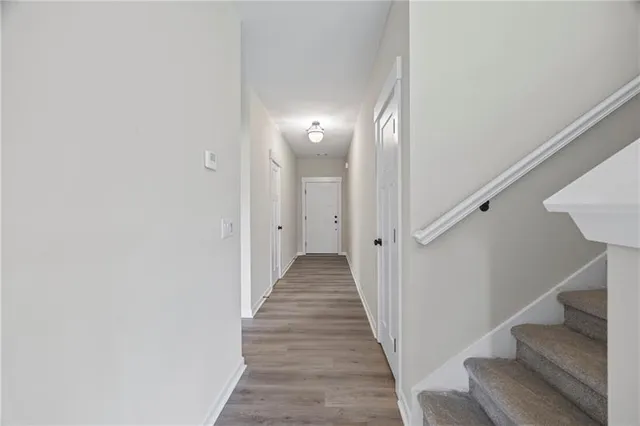 a view of a hallway with wooden floor and entryway