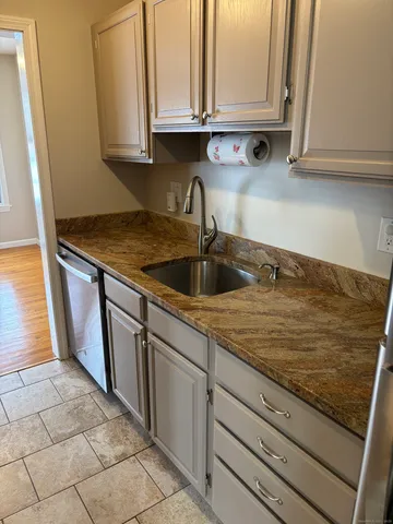 a kitchen with granite countertop a sink and cabinets