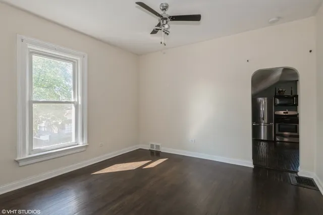 an empty room with wooden floor closet and windows