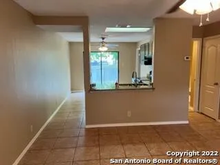 a view of a hallway with wooden floor and a bathroom