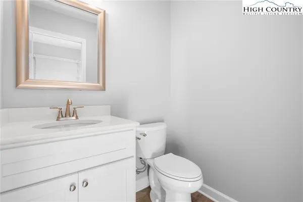 a bathroom with a toilet sink vanity and mirror